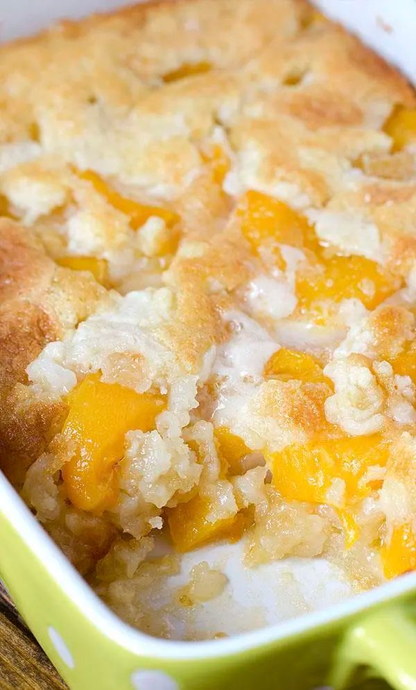 a casserole dish with peaches and rice in it on a wooden table