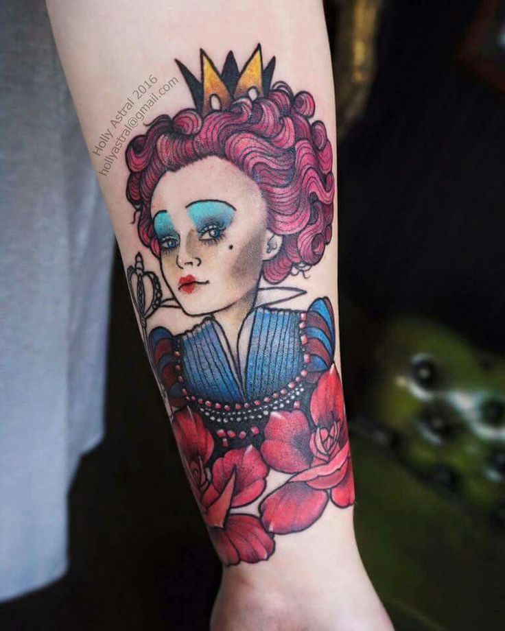 a woman with red hair and blue eyes has a tattoo on her arm