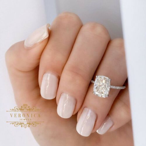 a woman's hand holding a ring with a diamond on it and a white background