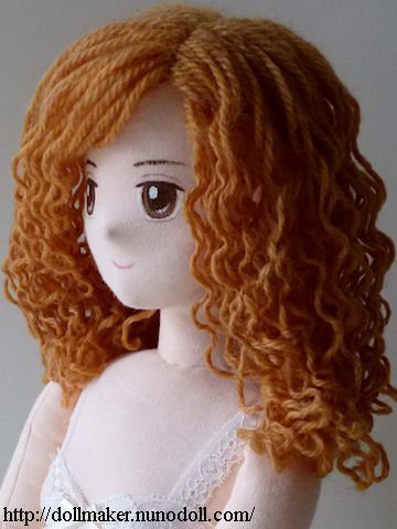 an image of a doll with long red hair and big eyes on the screen,