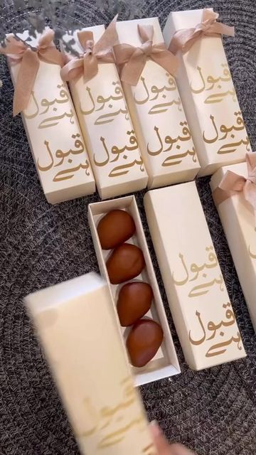 six chocolates in boxes with ribbons on them and one is being held by someone's hand