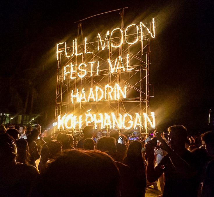 a large group of people standing in front of a sign that reads full moon festival val haddin hoi phhangan