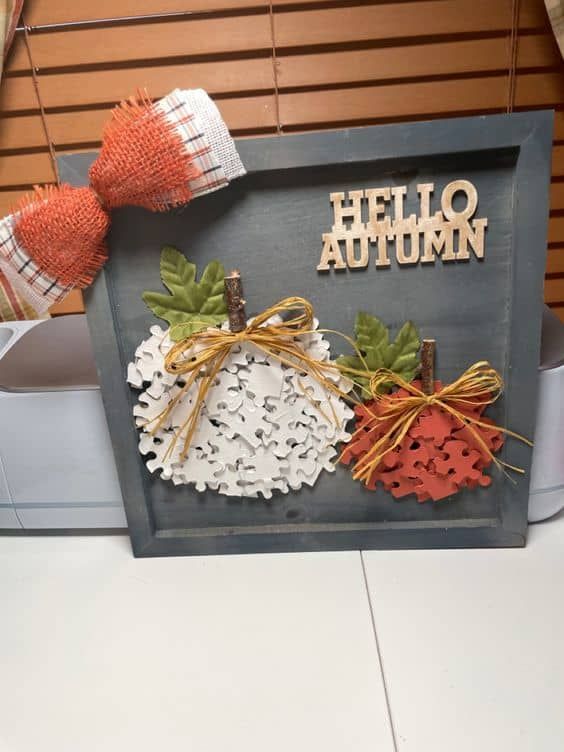 a wooden sign that says hello autumn with fall leaves and pumpkins on the front