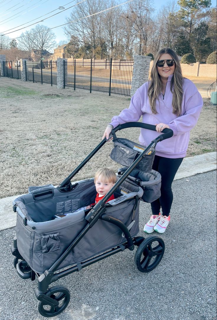 a woman pushing a stroller with a baby in it