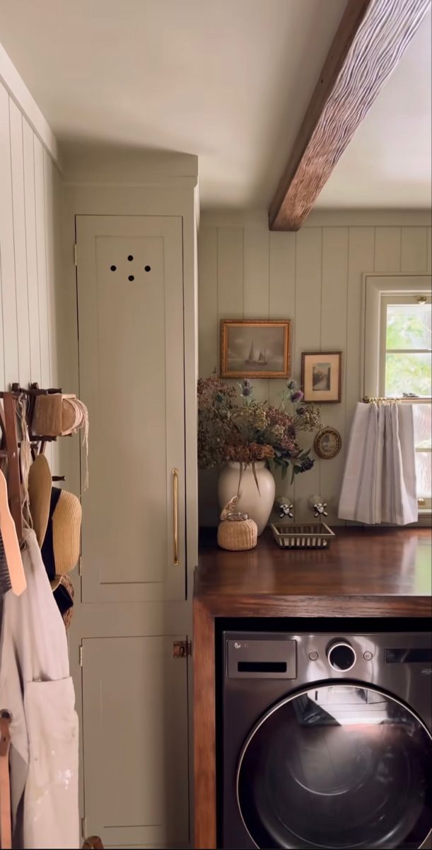 a washer and dryer in a small room with white cupboards on the wall