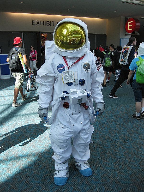 a man in an astronaut suit is walking through the airport with other people behind him