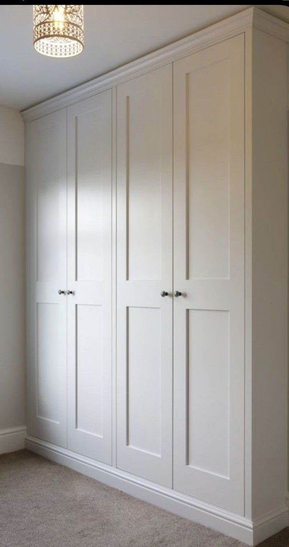 an empty room with white cupboards and carpet