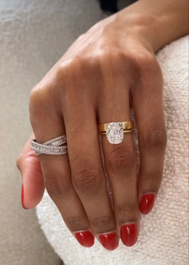 a woman's hand with two rings on her finger and one ring in the other