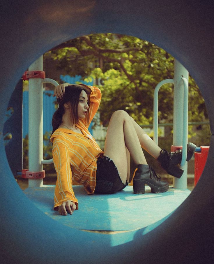 a woman sitting on top of a playground slide