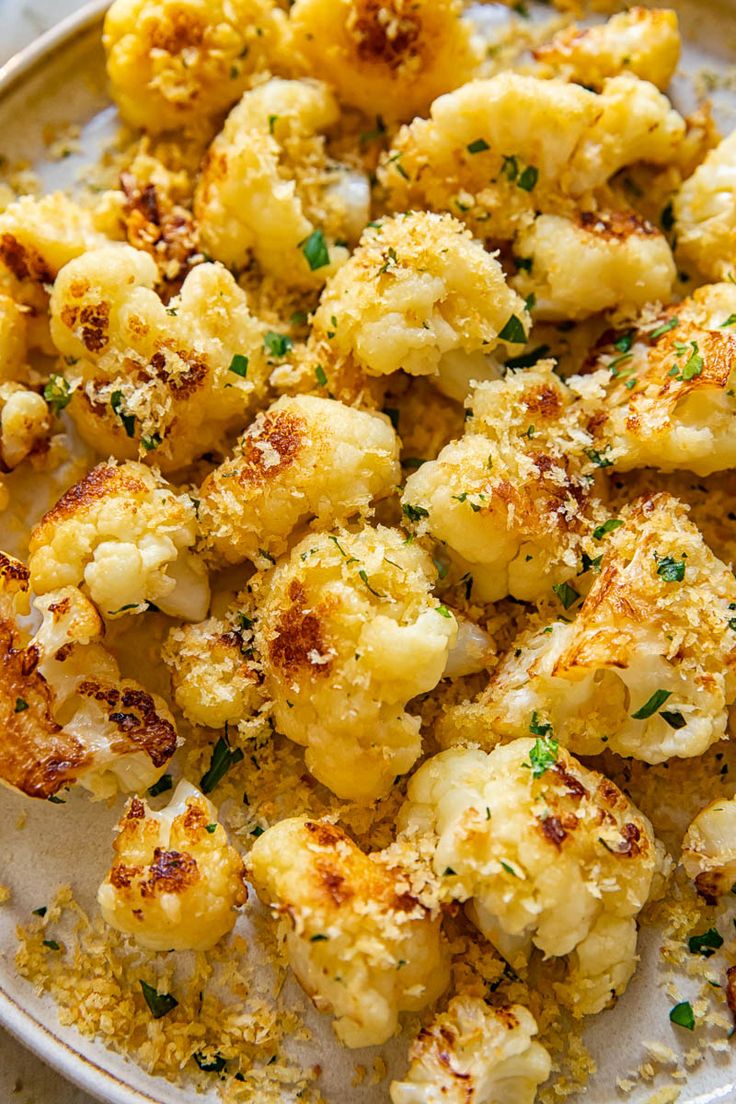 a white plate topped with cauliflower covered in seasoning