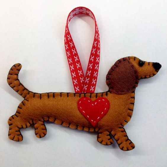 a dog ornament with a red heart hanging from it's side on a white background