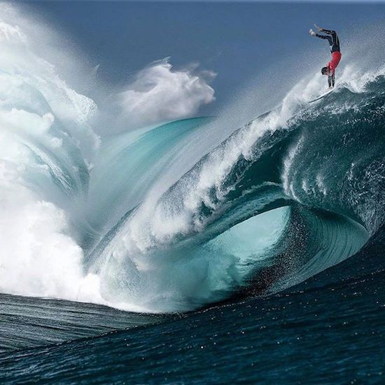 a man riding a wave on top of a surfboard