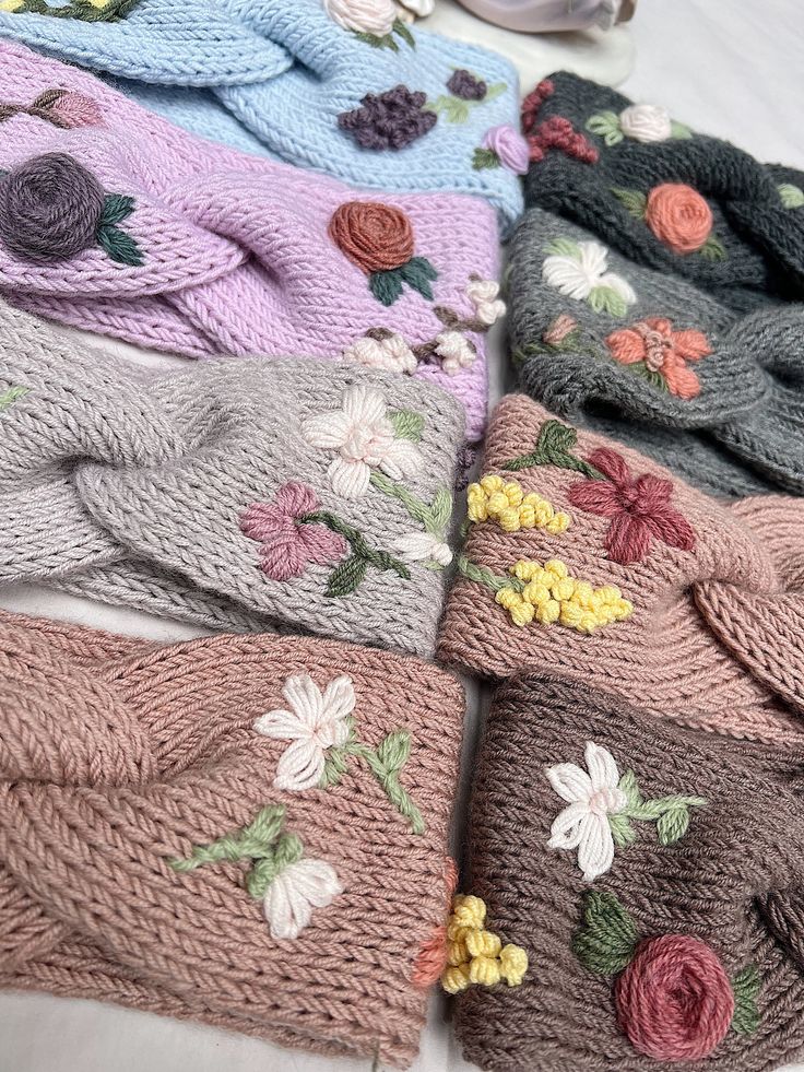 several knitted scarves with flowers on them