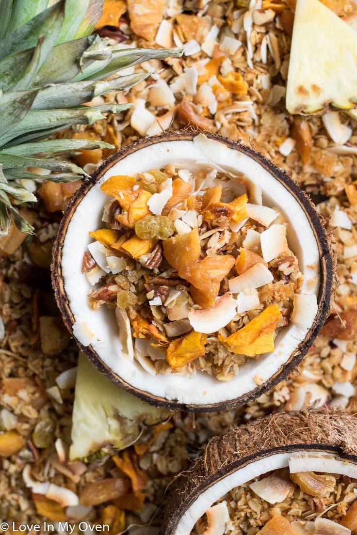 tropical fruit granola in a bowl with pineapples and coconut on the side