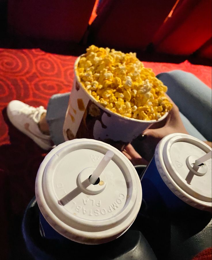 popcorn and drinks are sitting on the table