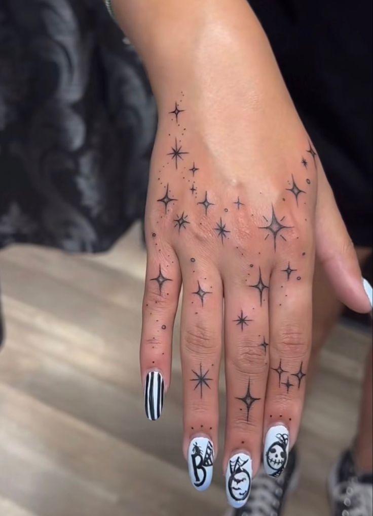 a woman's hand with black and white stars on it, while she has her fingers painted