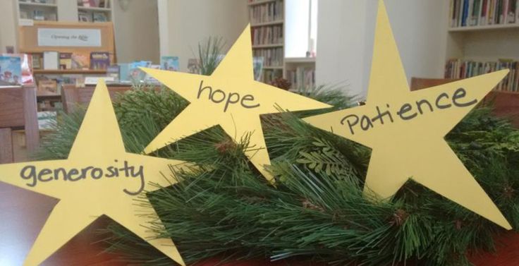 three yellow stars with words written on them sitting on top of a wooden table in front of bookshelves