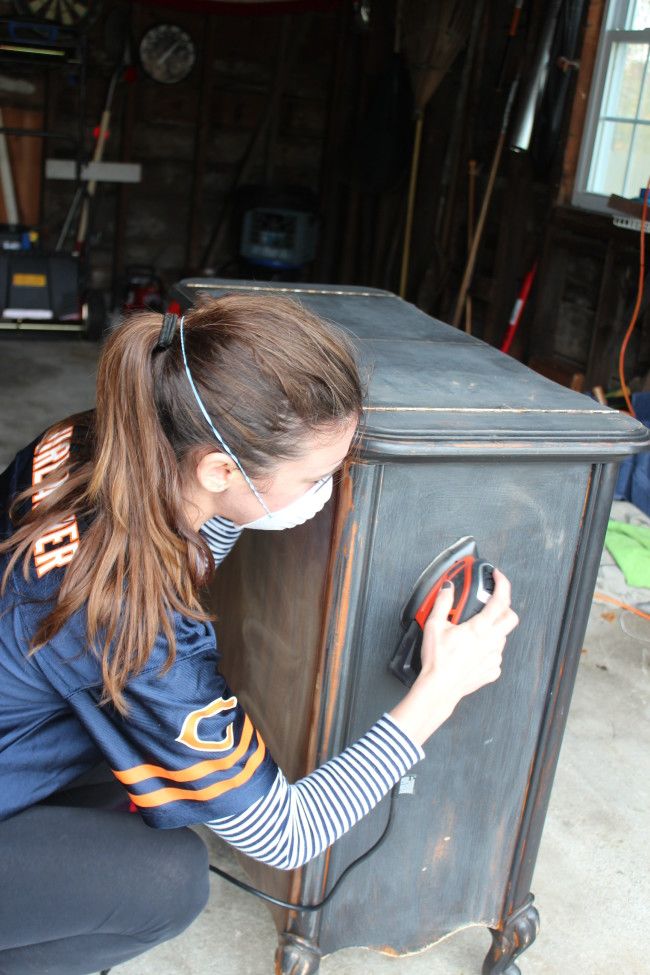 a woman is working on a piece of furniture