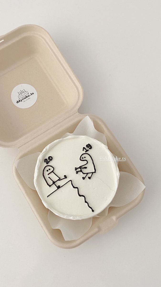 an open plastic container with a cake in the shape of a man and woman on it