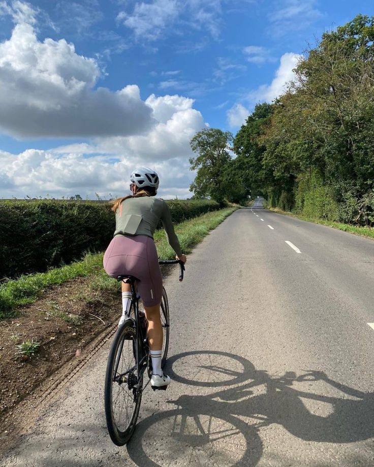 a woman riding her bike down the road