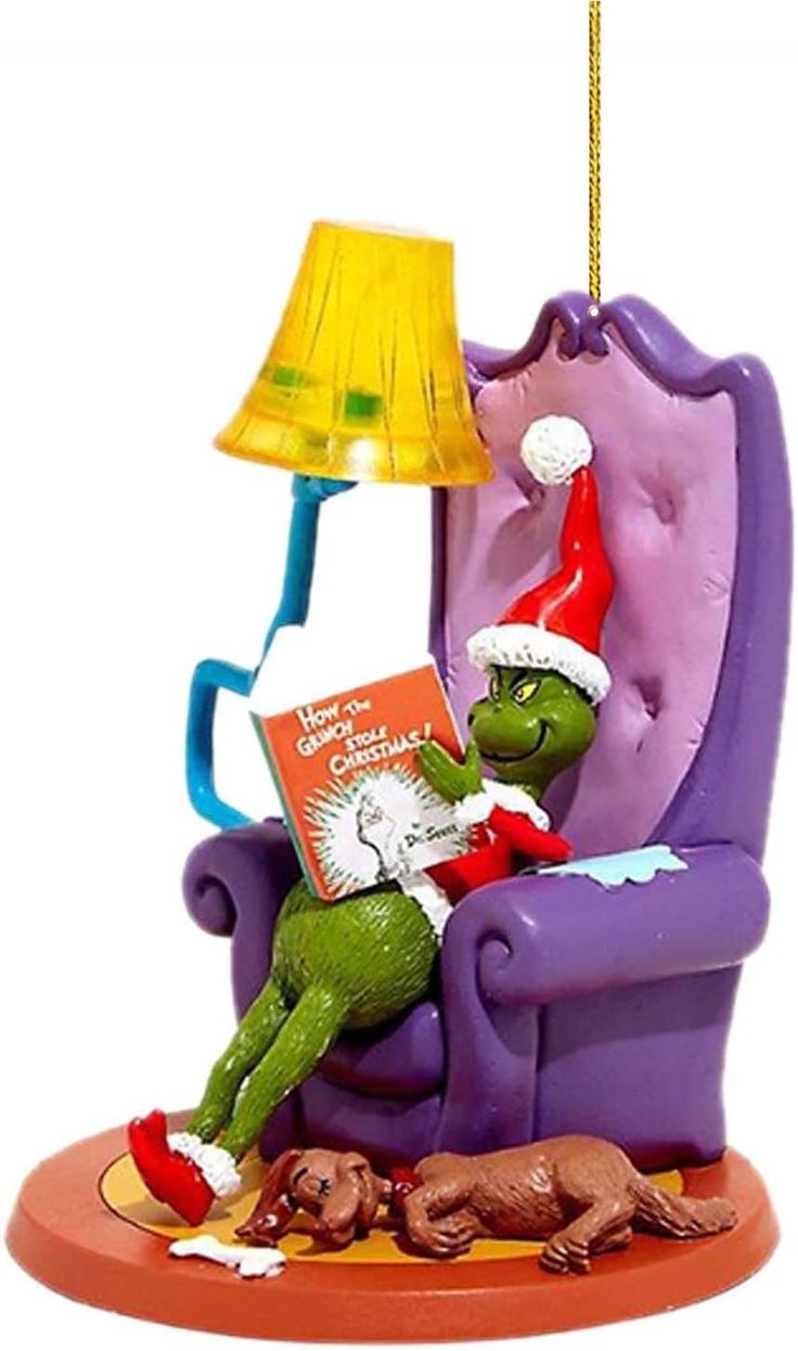 the grinch is reading a book while sitting in a purple chair with a lamp on it