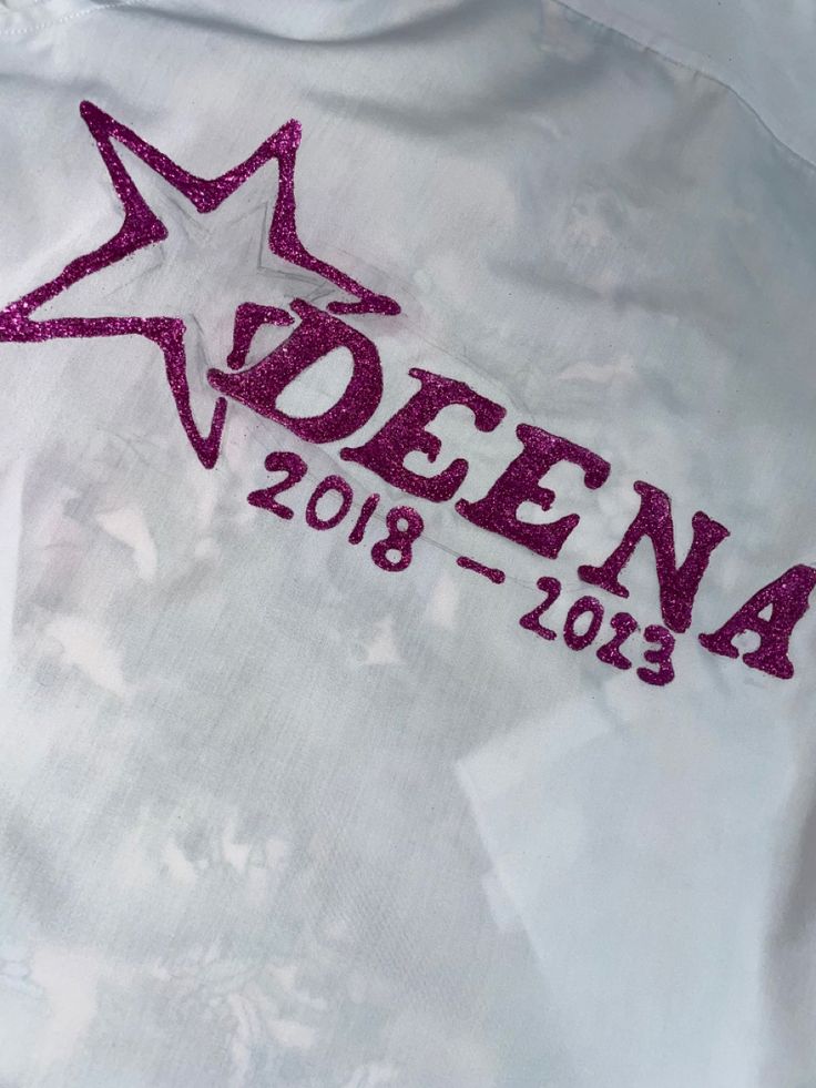 a white shirt with pink sequins and the name deena written on it