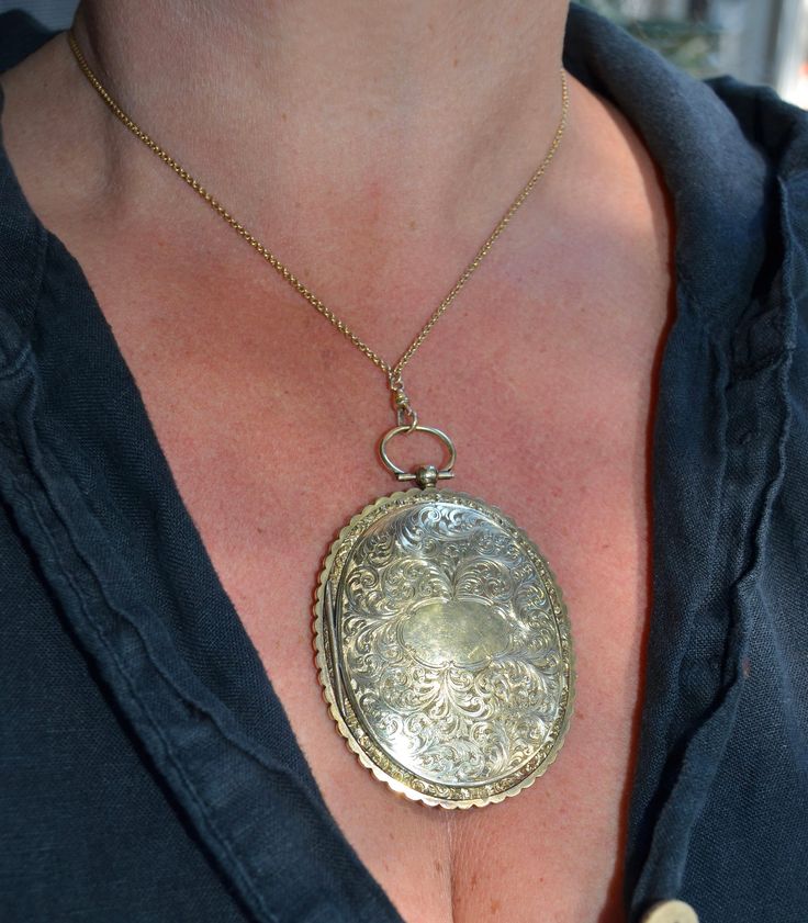 This is a massive locket. It is crafted from 10K yellow gold. The locket dates from the early 1800s, Georgian era. Each side of this masterpiece is hand etched. One side with loads of swirls and feathers; where as the opposing side is a floral scene. The edges are scalloped with a fine reprose' border on each side. The locket opens on one side to reveal its original frames and glass. This locket can be personalized by your local jeweler to etch in your initials or special saying on either side. Ornate Engraved Medallion Locket Necklace, Antique Coin Pendant Jewelry, Victorian Medallion Locket Necklace Hallmarked, Victorian Jewelry With Coin Pendant, Victorian Etched Medallion Locket Necklace, Antique Medallion Locket Necklace With Intricate Design, Traditional Oval Locket Necklace, Heirloom Locket Pendant Necklace With Intricate Design, Heirloom Pendant Locket Necklace With Intricate Design