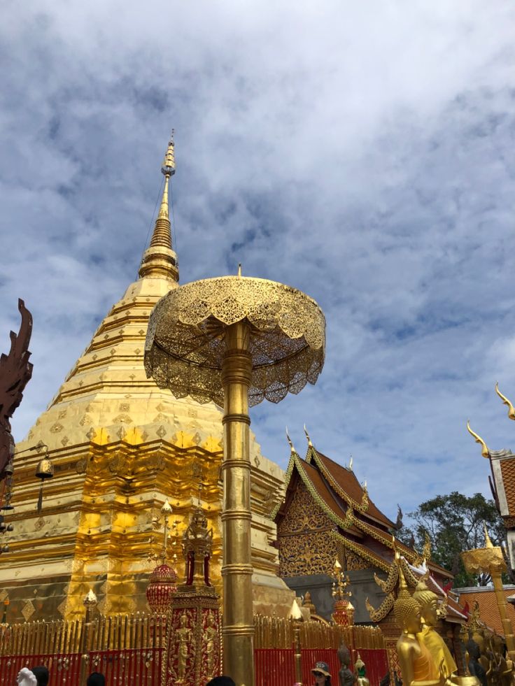 people standing in front of a golden pagoda