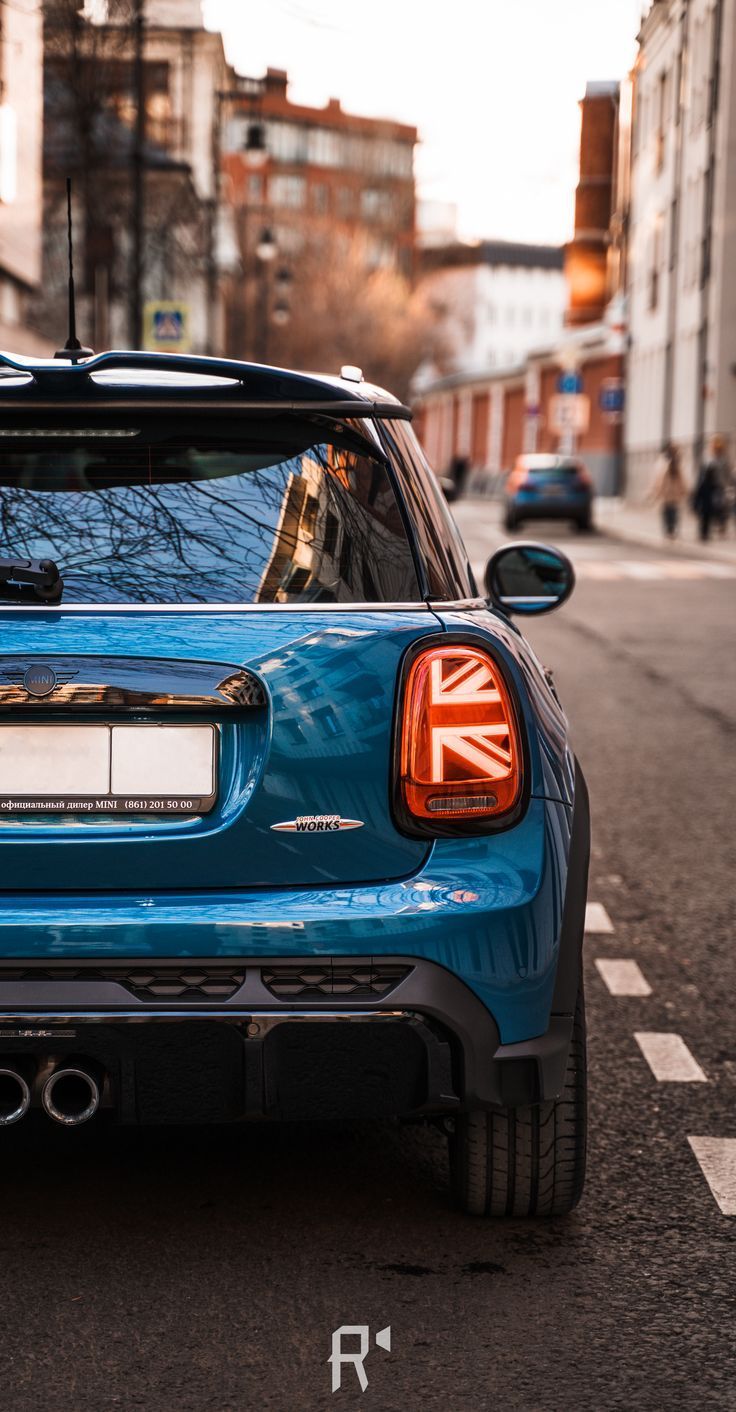 the back end of a blue minivan parked on the street