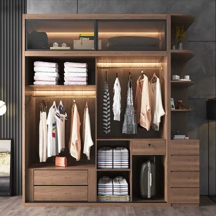 an open closet with clothes hanging on the shelves and other items in front of it