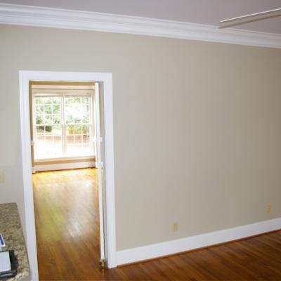 an empty living room with hard wood flooring and white trim on the door way