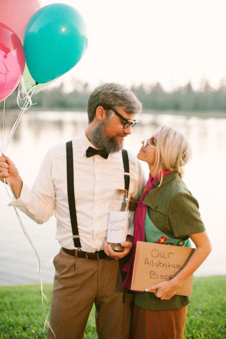 a man and woman standing next to each other holding balloons