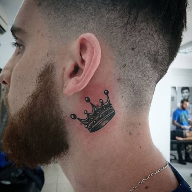 a man with a crown tattoo on his ear