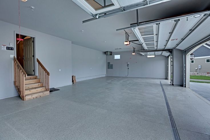 an empty garage with stairs leading up to the second floor