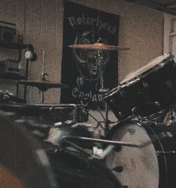 a drum set is shown in front of a sign that reads motorhead on it