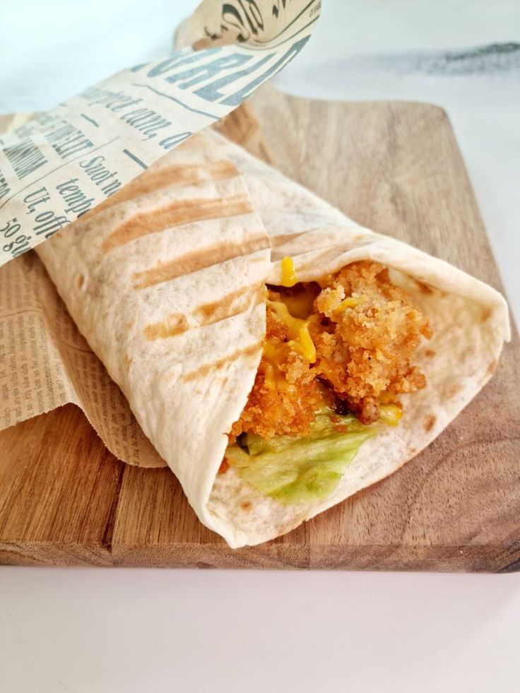 a burrito on a cutting board with a wrapper