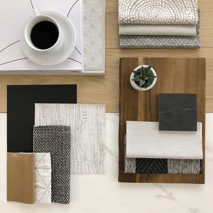 a table topped with lots of different types of rugs next to a cup of coffee