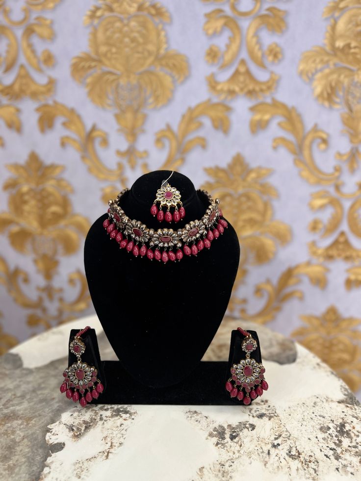 Indulge in the epitome of lavishness with our stunning Kundan and gemstone necklace set, adorned with radiant pearls and accompanied by complementary earrings. The customizable dori closure offers a flawless fit, while the secure push back closure adds a touch of effortless sophistication. This flawless set embodies grace and sophistication. Elegant Jeweled Jewelry Sets For Reception, Elegant Kundan Jewelry Sets With Stones, Pearl Beaded Jewelry For Reception, Pearl Beaded Jewelry For Receptions, Elegant Gemstone Jewelry Sets For Reception, Elegant Beaded Pearl Necklace For Receptions, Elegant Ruby Bridal Sets For Festive Occasion, Kundan Jewelry With Matching Earrings For Reception, Elegant Kundan Bridal Necklace With Stones