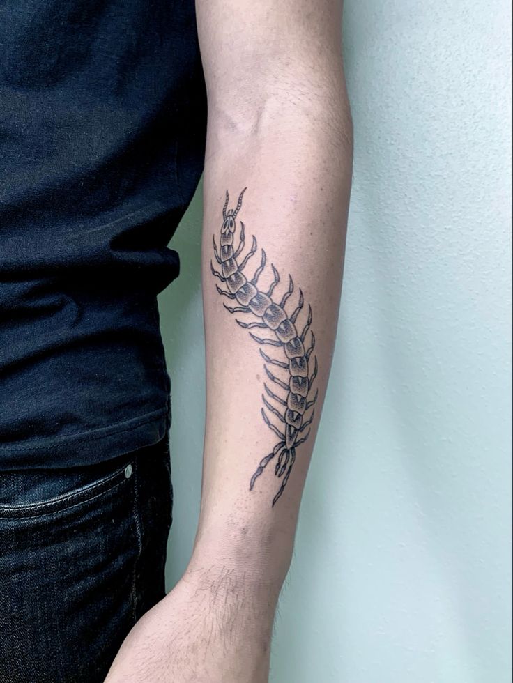 a man's arm with a fern tattoo on the left side of his arm