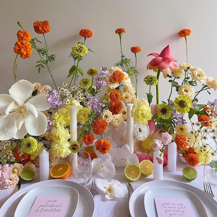 the table is set with flowers and place settings