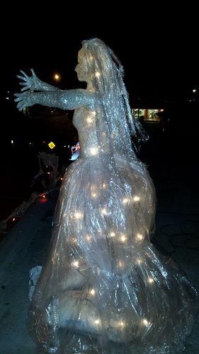 a statue is wrapped in plastic and has lights all over it's body as if she was dancing