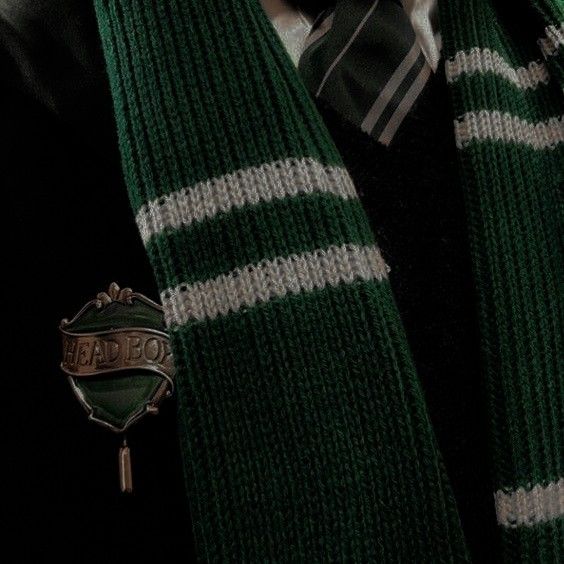 the tie is green with white stripes and a badge that says dead boy on it