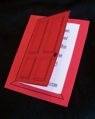 an open red door on top of a card