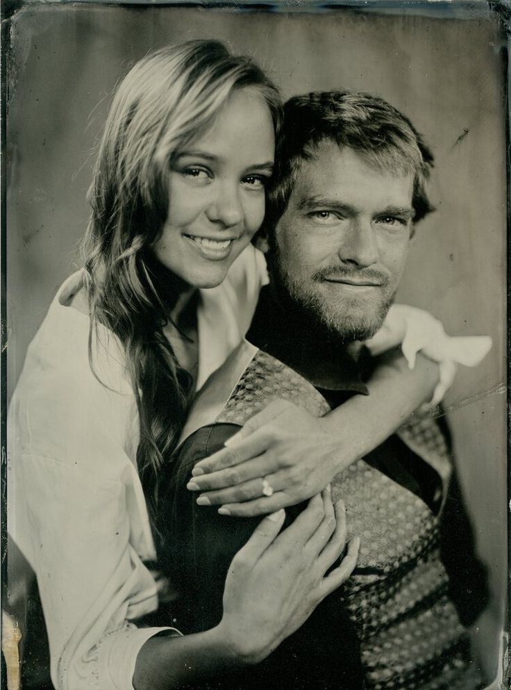 an old black and white photo of a man holding a woman