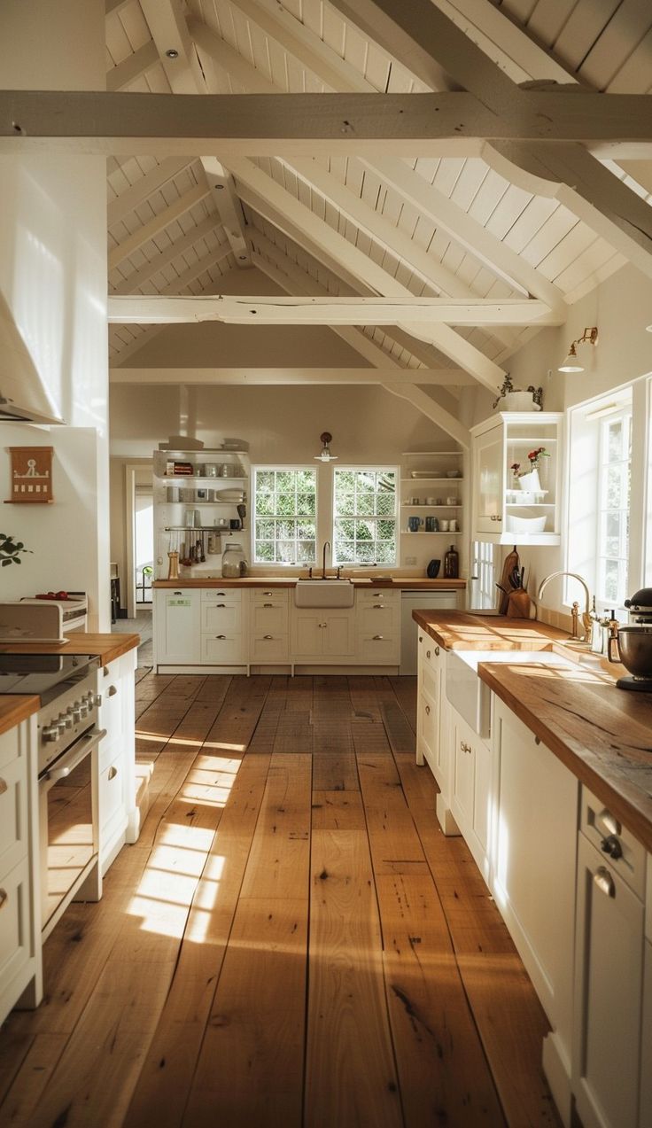 an open kitchen with wooden floors and white cabinets, along with lots of windows on the ceiling