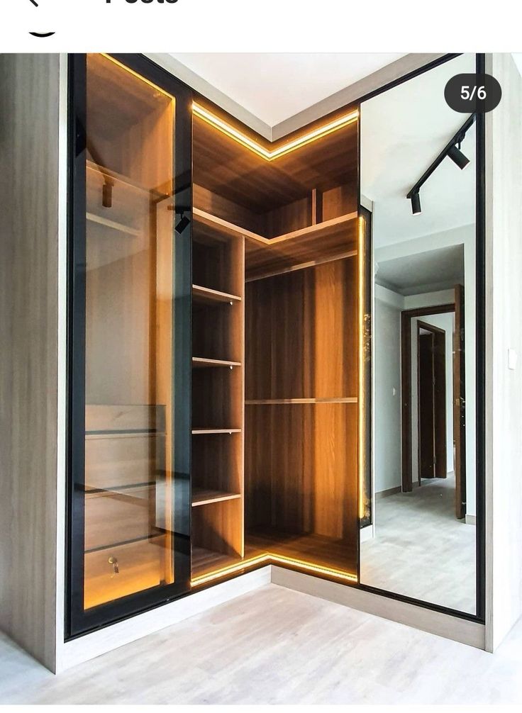 an open closet with mirrored doors and lights on the inside, in front of a mirror