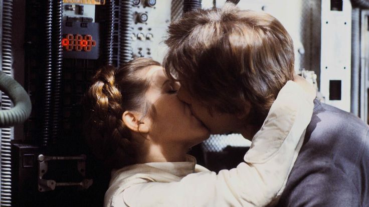 a man and woman kissing each other in front of an industrial machine with wires on it