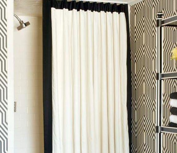 a bathroom with black and white wallpaper, shower curtain, toilet paper roll and towel rack