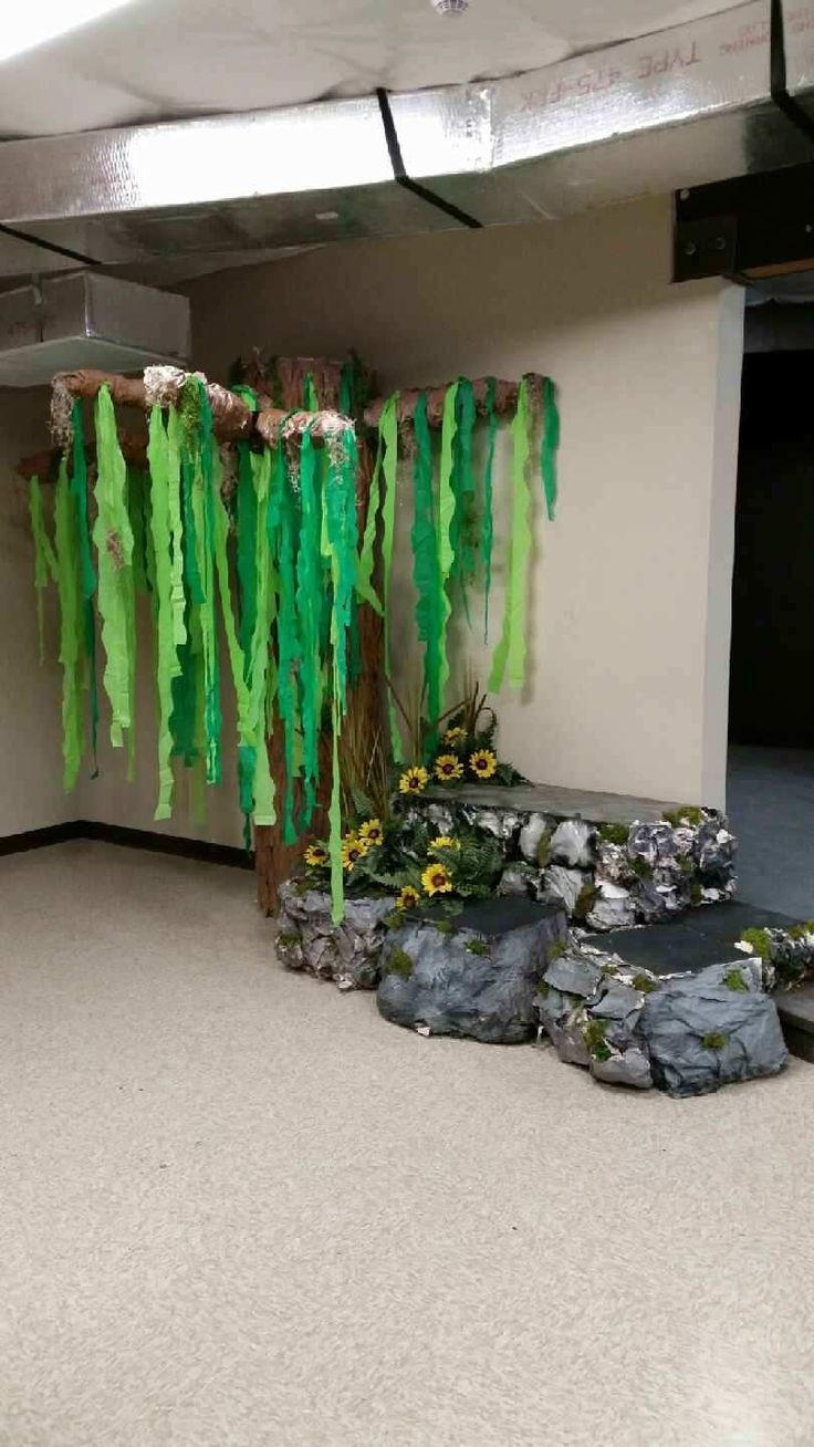 an empty room with green streamers hanging from the ceiling and rocks on the floor