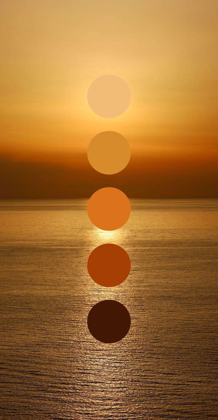 the sun is setting over the ocean with five different circles in front of it that are reflecting on the water